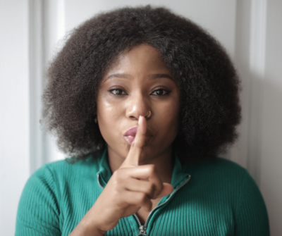 Woman holding finger to mouth